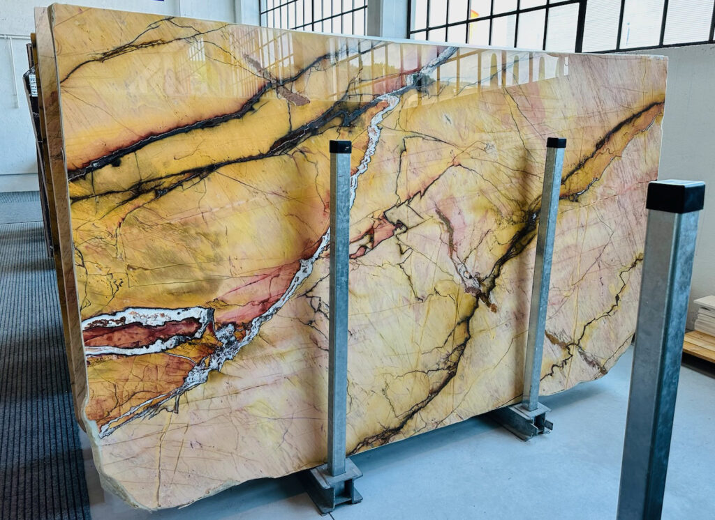 Tunisian Marble slab with yellow, pink, and black veining in a showroom