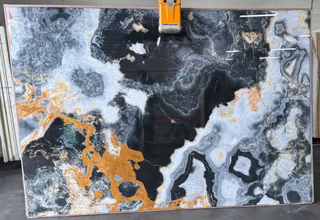 Black Onyx natural stone slab with translucent gray crystals and amber veining.