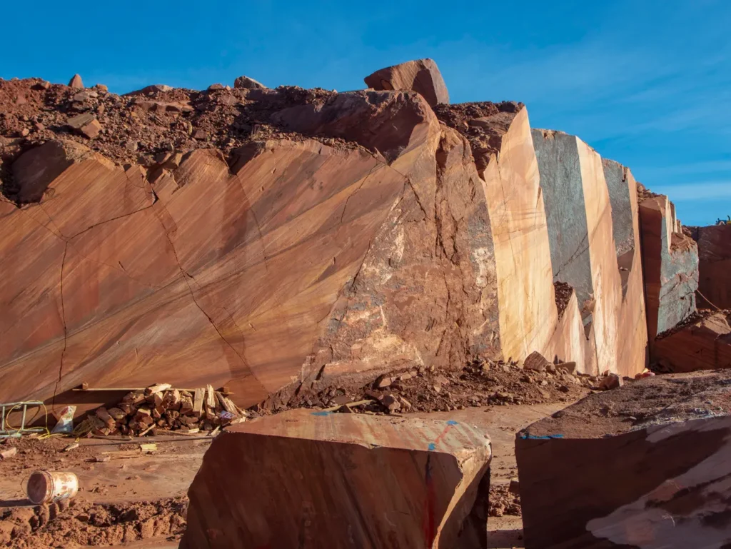 Exposed meta quartzite formation at the Rainbow Quarry in Goodsprings, Nevada, showing the natural geological layers from which Tupelo Honey is quarried.