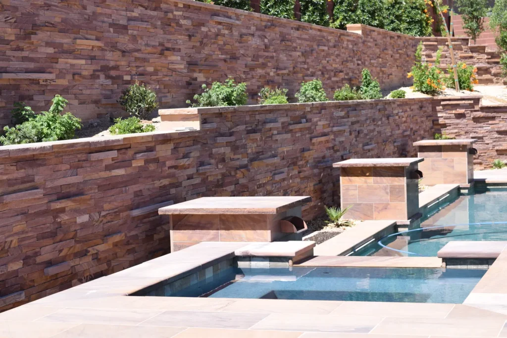 Luxury swimming pool featuring Las Vegas Rock Desert Blend stone veneer walls and custom meta quartzite water features.