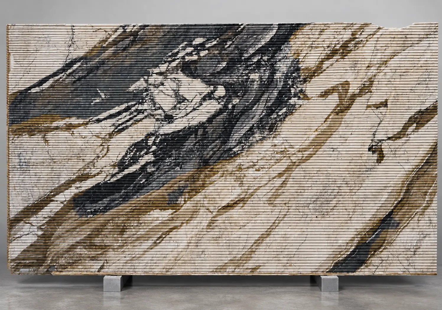 Breccia Fantastica Italian marble slab with deep horizontal grooves and dramatic black, cream, and gold veining.