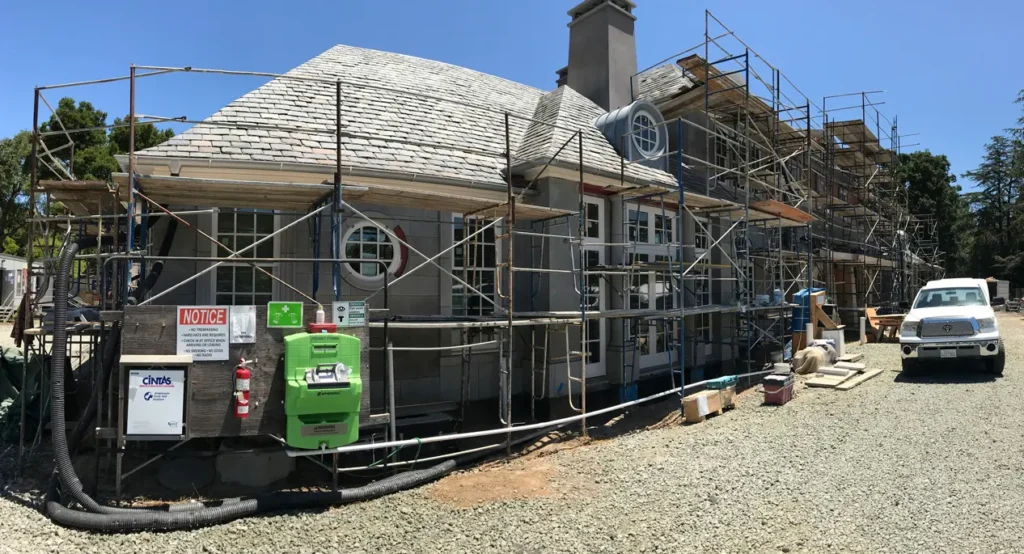 Custom stone-clad luxury residence under construction with precision-cut exterior wall panels supplied by The World of Stone