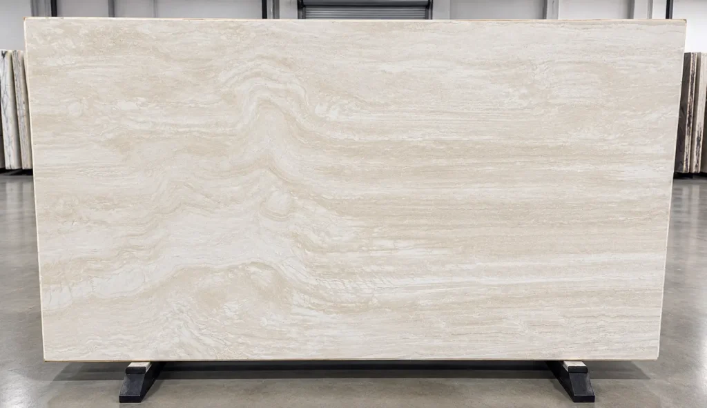 Italian Navona Vein Cut Travertine slab featuring warm ivory and cream tones with delicate horizontal veining, displayed on an A-frame.