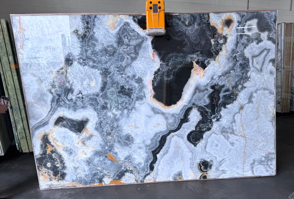 Silver Grey Onyx slab 26 featuring dramatic black and charcoal formations surrounded by translucent silver-gray crystalline patterns, layered veining, and subtle amber-gold accents.